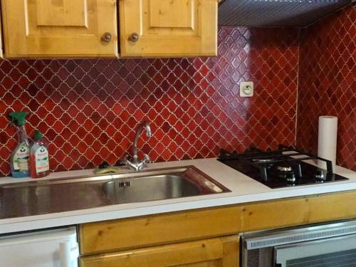 - une cuisine avec un évier en acier inoxydable et du carrelage rouge dans l'établissement À Louer Les Gets: 2 Pièces, 4 Pers, Centre, Wifi, Draps et Serviettes Inclus - FR-1-802-23, aux Gets