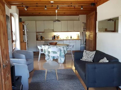 un salon avec une table et un canapé bleu dans l'établissement Les Gets : Triplex 5 pièces pour 8 pers, proche télésiège, navette, balcon, ski/vélo - FR-1-802-1, aux Gets