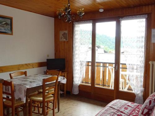 une salle à manger avec une table et un balcon dans l'établissement Appartement 2 Pièces Les Gets - 4 Pers, Centre, Balcon, Parking, Wifi, Navette Gratuite - FR-1-802-34, aux Gets