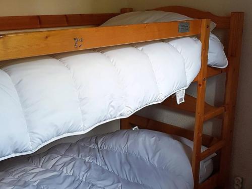 - deux lits superposés avec des oreillers blancs dans l'établissement Les Gets : Triplex 5 pièces pour 8 pers, proche télésiège, navette, balcon, ski/vélo - FR-1-802-1, aux Gets