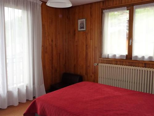 - une chambre avec un lit rouge et deux fenêtres dans l'établissement Appartement 2 Pièces Les Gets - 4 Pers, Centre, Balcon, Parking, Wifi, Navette Gratuite - FR-1-802-34, aux Gets