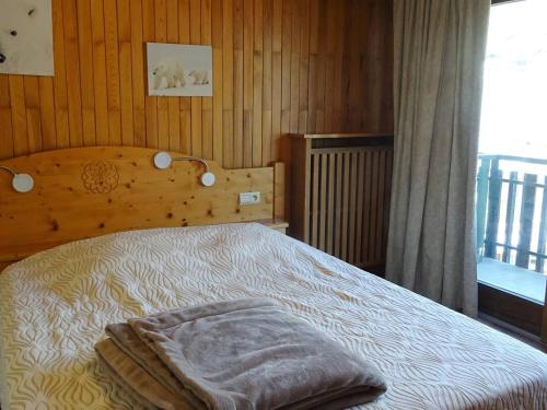 une chambre avec un lit avec une couverture dessus dans l'établissement Appartement spacieux 2 pièces aux Gets - 4 pers, balcon, centre village, wifi, draps et serviettes inclus - FR-1-802-35, aux Gets