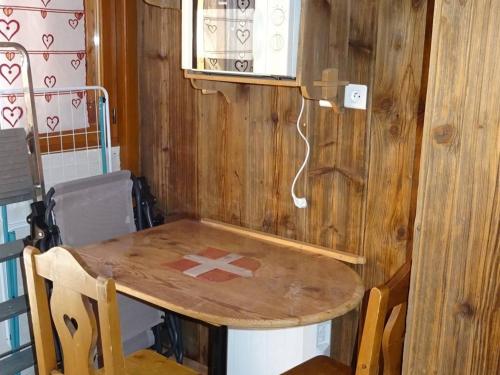 - une table en bois dans une chambre avec une table et des chaises dans l'établissement Location Les Gets : Spacieux 4 pièces pour 9 pers, proche centre, parking privé, terrasse ensoleillée - FR-1-802-33, aux Gets