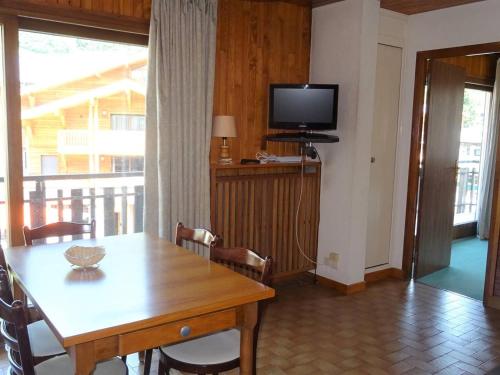 une salle à manger avec une table et une télévision dans l'établissement Location 2 pièces Les Gets, centre-ville, 4 pers., WiFi, draps et serviettes inclus - FR-1-802-6, aux Gets
