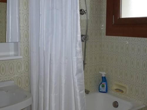 La salle de bains est pourvue d'un rideau de douche blanc et d'un lavabo. dans l'établissement Studio central Les Gets - 2 pers - WiFi - Draps/Serv inclus - Proche commerces & remontées - FR-1-802-42, aux Gets