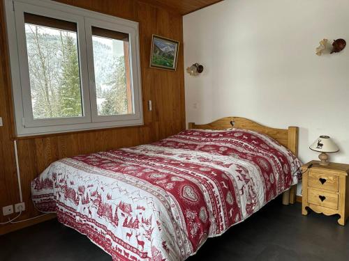 - une chambre dotée d'un lit avec une couverture rouge et blanche dans l'établissement Les Gets : Duplex 6 pièces pour 12 pers., wifi, garage, proche pistes – Draps et serviettes inclus l’hiver - FR-1-802-9, aux Gets