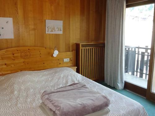 une chambre avec un lit avec une grande fenêtre dans l'établissement Les Gets: Appartement 2P, 4 pers. Centre, WiFi, Draps/Serviettes inclus, Proche Commerces et ESF - FR-1-802-15, aux Gets