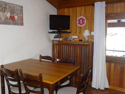 une salle à manger avec une table et une télévision dans l'établissement Appartement 2 pièces lumineux 4 pers, cœur des Gets, WiFi, draps et serviettes inclus, proche commodités - FR-1-802-16, aux Gets
