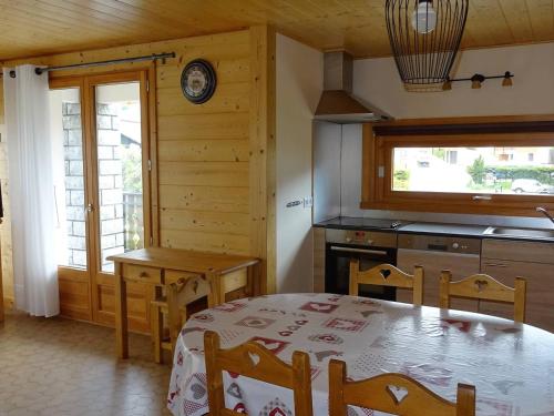 une salle à manger avec une table et une cuisine dans l'établissement Appartement 3 Pièces, 6 Pers - Centre Les Gets, Garage, WIFI, Balcon, Navette Gratuite - FR-1-802-24, aux Gets