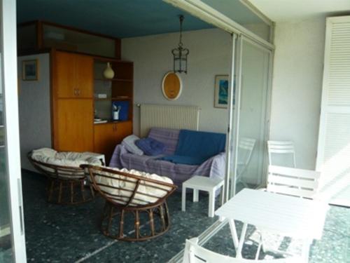 un salon avec un canapé et une chaise dans l'établissement Appartement T3 au Grau-du-Roi, accès plage, parking - FR-1-731-80, au Grau-du-Roi