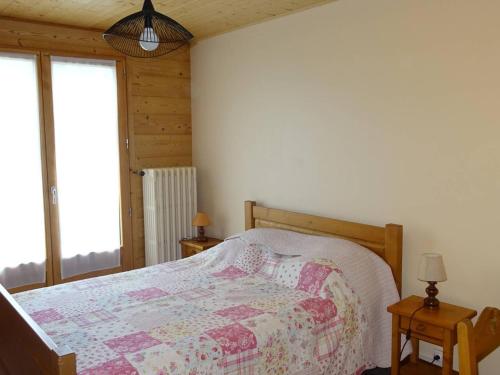 une chambre avec un lit avec une couette dessus dans l'établissement Appartement 3 Pièces, 6 Pers - Centre Les Gets, Garage, WIFI, Balcon, Navette Gratuite - FR-1-802-24, aux Gets
