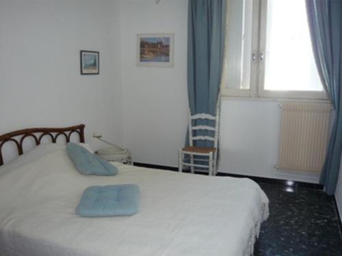 une chambre avec un lit avec deux oreillers bleus dessus dans l'établissement Appartement T3 au Grau-du-Roi, accès plage, parking - FR-1-731-80, au Grau-du-Roi