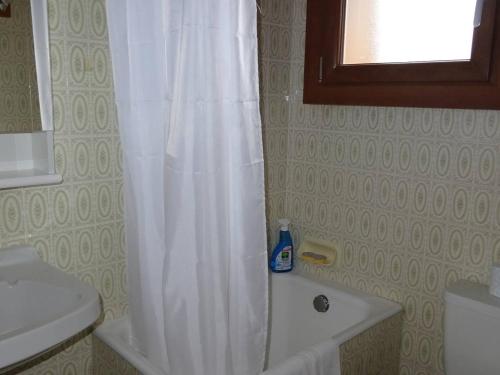 La salle de bains est pourvue d'une douche avec rideau de douche blanc. dans l'établissement Studio aux Gets, 2 pers, centre-ville, Wifi, draps et serviettes inclus - FR-1-802-26, aux Gets