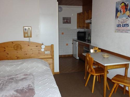 une chambre avec un lit et une table et une cuisine dans l'établissement Studio aux Gets, 2 pers, centre-ville, Wifi, draps et serviettes inclus - FR-1-802-26, aux Gets