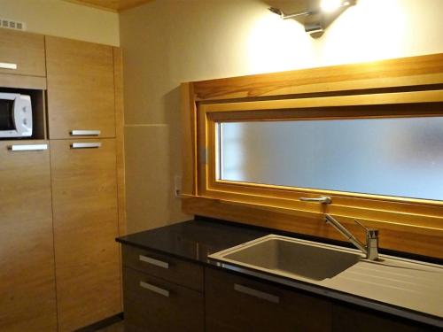 une cuisine avec un évier et un micro-ondes dans l'établissement Les Gets: Spacieux 3 Pièces 7 Pers, Lumineux avec Balcon, Parking, WIFI, Proche Commerces et ESF - FR-1-802-8, aux Gets