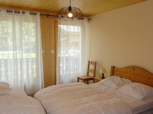 - une chambre avec 2 lits et une fenêtre avec une chaise dans l'établissement Les Gets 2 Pièces Rénové, 5 Pers, Centre, Wifi, Garage - FR-1-802-11, aux Gets