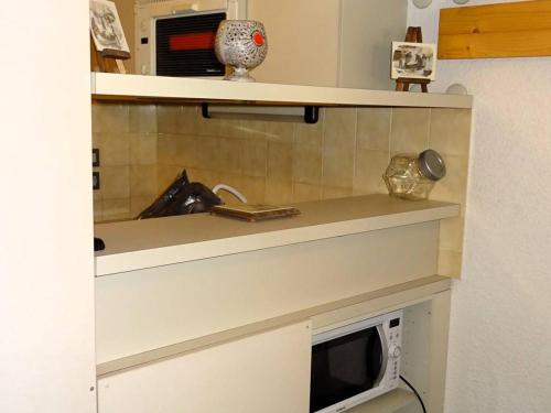 une cuisine avec un évier et un micro-ondes dans l'établissement Grand studio duplex lumineux - 6 pers - centre Les Gets - parking privé - à 400 m des pistes - FR-1-802-37, aux Gets