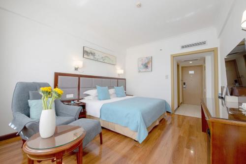 a hotel room with a bed and a chair and a couch at 深圳江苏宾馆 in Shenzhen
