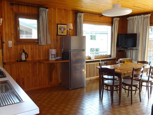 une cuisine avec une table et un réfrigérateur en acier inoxydable dans l'établissement Appartement 3 Pièces, 6 Pers, Centre des Gets, WiFi, Draps Inclus, Parking Privé - FR-1-802-17, aux Gets