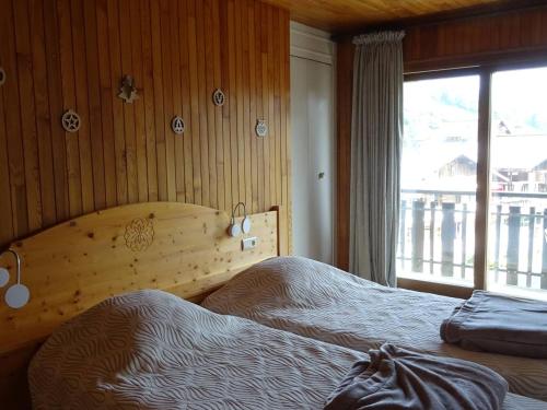 une chambre avec deux lits et une fenêtre dans l'établissement Appartement 3 Pièces, 6 Pers, Centre des Gets, WiFi, Draps Inclus, Parking Privé - FR-1-802-17, aux Gets