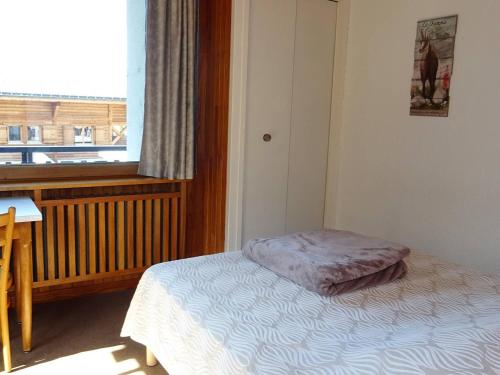 une petite chambre avec un lit et une fenêtre dans l'établissement Spacieux 2 Pièces au Cœur des Gets - 4 Pers, Balcon, Wifi, Draps et Serviettes Offerts - FR-1-802-47, aux Gets