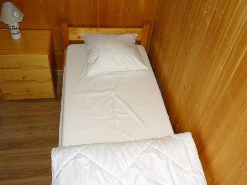 un lit avec des draps blancs et des oreillers dans une chambre dans l'établissement Appartement cosy 2 pièces aux Gets - 3 pers - Garage - Proche pistes et navette - FR-1-802-20, aux Gets