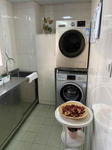 a kitchen with a washing machine and a pizza on a table at 深圳江苏宾馆 in Shenzhen