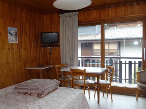 une chambre avec un lit, une table et une fenêtre dans l'établissement Studio cosy Les Gets - Centre, 2 pers, Wi-Fi, Draps & Serviettes Inclus - FR-1-802-29, aux Gets