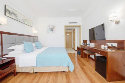a bedroom with a bed and a desk and a television at 深圳江苏宾馆 in Shenzhen