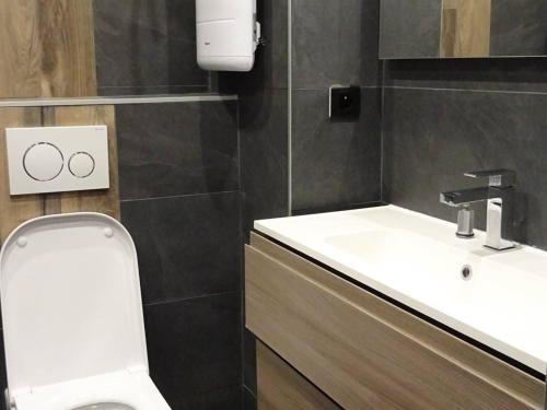 une salle de bain avec des toilettes blanches et un lavabo dans l'établissement Studio cosy, lumineux au centre des Gets, 4 pers, balcon, proche pistes (100m), commerces à pied. - FR-1-802-44, aux Gets