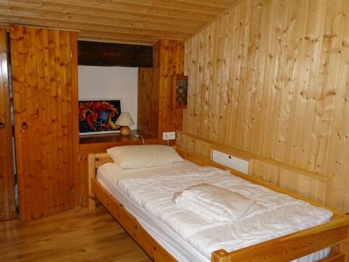 Ce lit se trouve dans un dortoir doté de murs en bois et de parquet. dans l'établissement Appartement 5 pièces 92m² aux Gets - Lumineux, Proche Pistes et Commerces, Garage inclus - FR-1-802-46, aux Gets