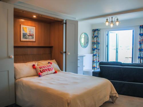 ein Schlafzimmer mit einem Bett und einer Couch in der Unterkunft 36 The Salcombe in Salcombe