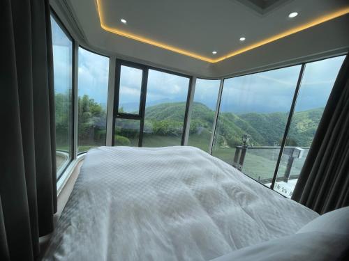 a bedroom with a bed in front of a large window at 深山林內民宿 in Zhushan