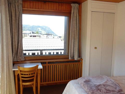 - une chambre avec une fenêtre, un bureau et un lit dans l'établissement Spacieux 2 Pièces au Coeur des Gets - 4 Pers - Balcon, WiFi, Draps et Serviettes Inclus - FR-1-802-53, aux Gets