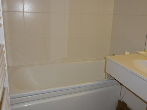 une salle de bain blanche avec une baignoire et un lavabo dans l'établissement Studio cabine lumineux aux Gets, 4 pers, proche piste et commerces, parking privé - FR-1-802-58, aux Gets