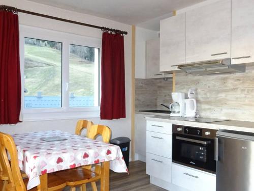 une cuisine avec une table et une cuisine avec une table et des chaises dans l'établissement Les Gets - 2 Pièces Rénové, 5 Pers, Centre, Confort, Garage, Pied des Pistes et Commerces - FR-1-802-79, aux Gets
