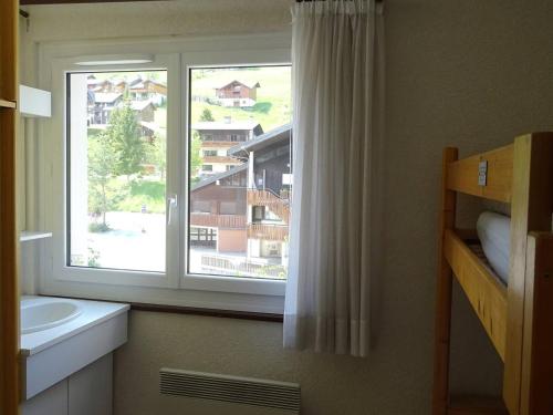 La salle de bains est pourvue d'une fenêtre donnant sur un bâtiment. dans l'établissement Les Gets - 2 Pièces Rénové, 5 Pers, Centre, Confort, Garage, Pied des Pistes et Commerces - FR-1-802-79, aux Gets
