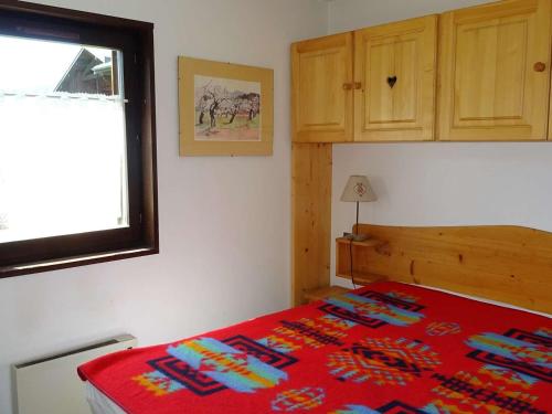 une chambre avec un lit avec une couverture rouge dans l'établissement Appartement Confortable 2 Pièces + Cabine, 5 Pers. - Centre Les Gets, Parking Inclus - FR-1-802-60, aux Gets