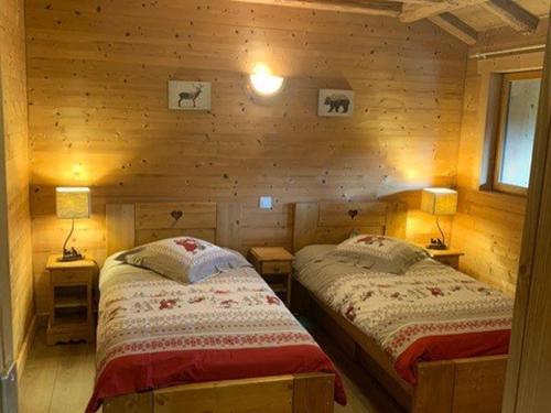 une chambre avec deux lits dans une cabane en rondins dans l'établissement Les Gets - Appartement 3 Pièces - 7 Pers - 100m Télésiège - Wifi - Parking - FR-1-802-85, aux Gets