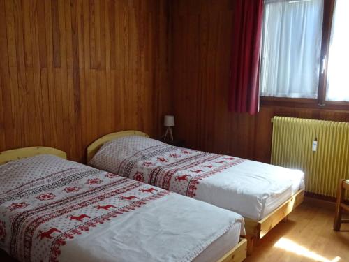 deux lits dans une chambre aux murs en bois dans l'établissement Appartement 3 pièces - 6 pers - Terrasse, Garage, Wi-Fi - Proche Pistes - Les Gets - FR-1-802-66, aux Gets