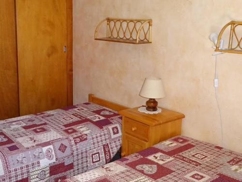 une chambre avec deux lits et une lampe sur une table de chevet dans l'établissement Appartement confortable pour 5 pers - Sud, balcon, garage - 300m commerces/pistes, Les Gets - FR-1-802-67, aux Gets