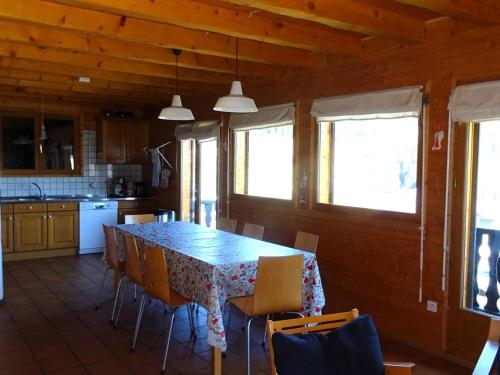 une cuisine avec une table et des chaises dans une pièce dans l'établissement Chalet Les Gets 10 pers - Garage - WIFI - Proche centre - FR-1-802-69, aux Gets