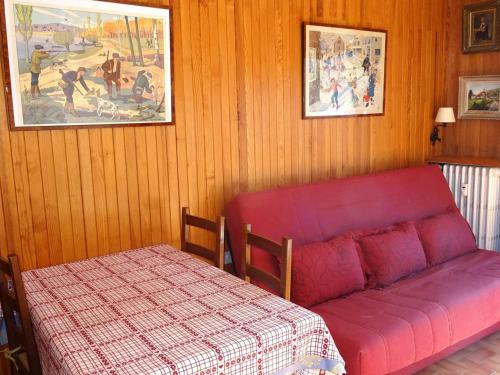 - un canapé rouge dans une chambre avec un lit dans l'établissement Location Studio Les Gets - 4 pers - Centre, parking, au calme - FR-1-802-77, aux Gets