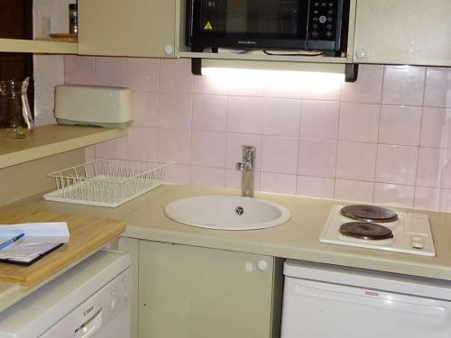 une petite cuisine avec un évier et un micro-ondes dans l'établissement Studio Cabine Confortable 4 Pers., Centre des Gets, Proche Commerces et Pistes - FR-1-802-78, aux Gets