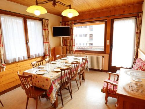 une salle à manger avec une longue table et des chaises dans l'établissement Appartement familial lumineux 8 pers, proche pistes Les Gets, draps et serviettes inclus l'hiver - FR-1-802-87, aux Gets