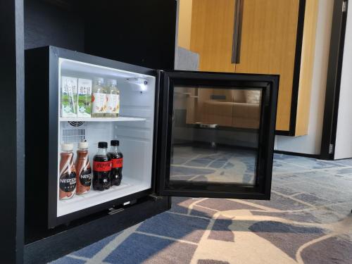 an open refrigerator filled with bottles of soda at 成都V hotel精品酒店 in Chengdu