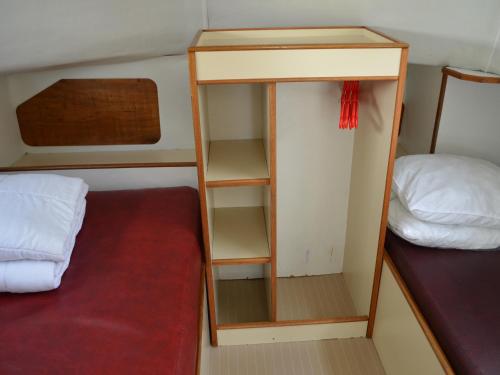 a small room with a bed and a book shelf at Bateau confortable à quai pour 5 pers, Pontailler-sur-Saône, proche commerces - API-1-46-16 in Pontailler-sur-Saône