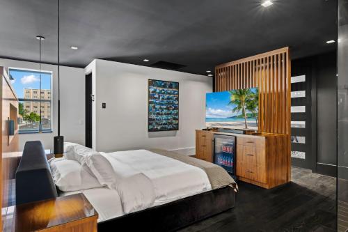 a bedroom with a large bed and a television at Modern City Loft in Downtown River District in Fort Myers