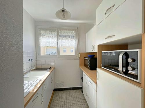 une cuisine blanche avec un évier et un micro-ondes dans l'établissement Studio Charmant - Plage et Centre à Pied, Résidence Sécurisée - FR-1-646-72, à Berck-sur-Mer