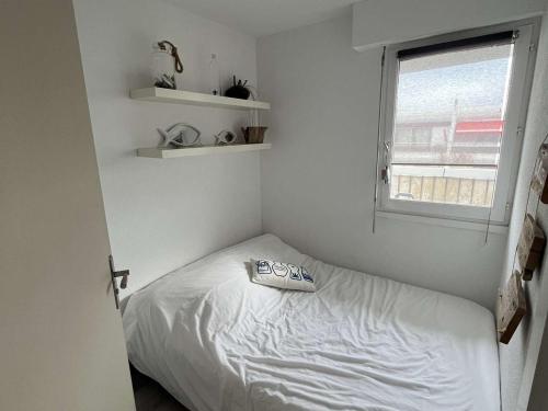 une petite chambre avec un lit et une fenêtre dans l'établissement Appartement T2 climatisé à 200m plage, terrasse, parking, 4 couchages - La Grande-Motte - FR-1-250-291, à La Grande Motte